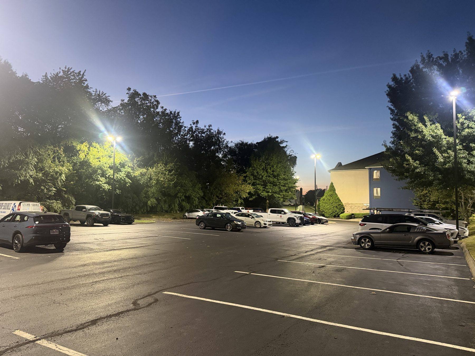 Marked parking spaces in the lot with overhead lighting