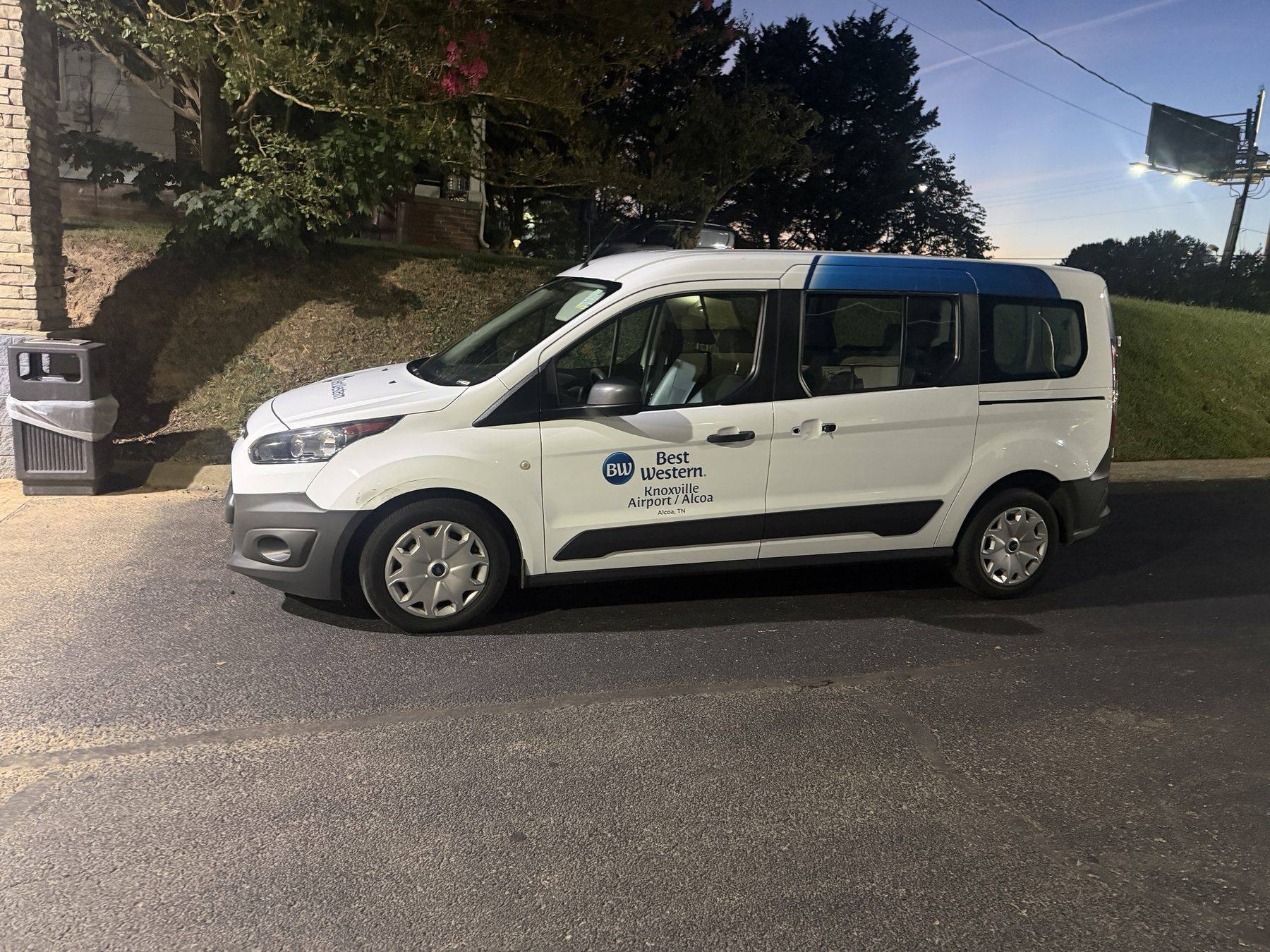 The airport shuttle van parked at the property entrance